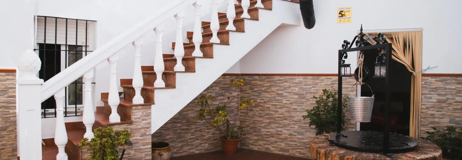 Patío de la casa rural con escalera de acceso a la terraza