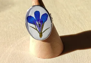 Anilo ajustable de acero con baño en plata. Flor Lobelia azul sobre base de resina pigmentada en blanco.